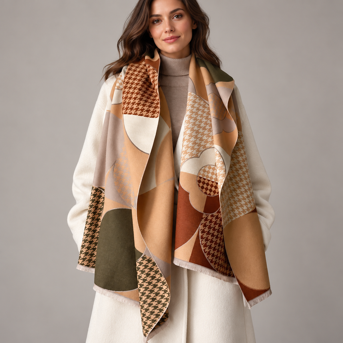 Brown and ivory geometric blanket scarf, worn over an ivory coat
