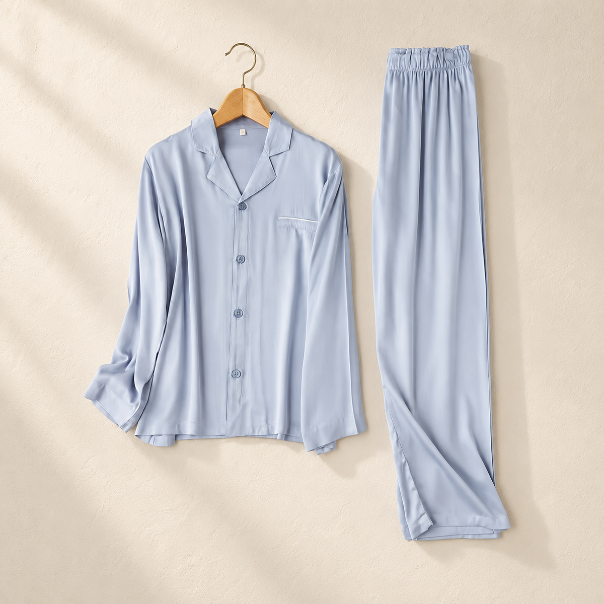 front photograph of the light-blue satin pajama top and trousers; one individual set.