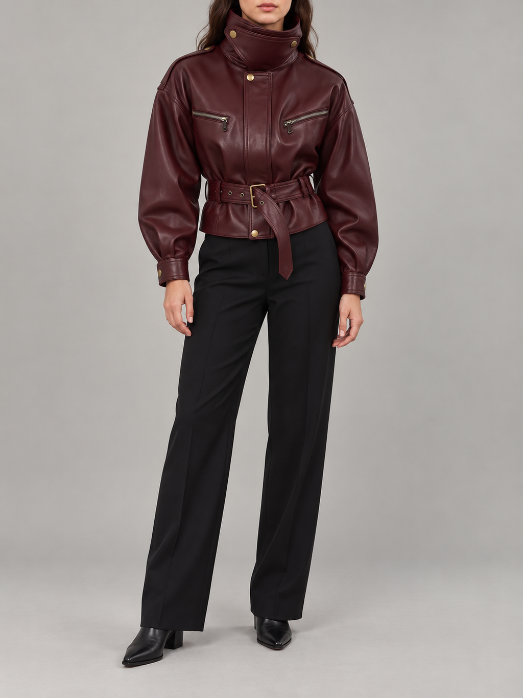 burgundy leather-look short jacket with stand collar, gold-tone snaps, two horizontal zip chest pockets and matching belted waist, front view on a model
