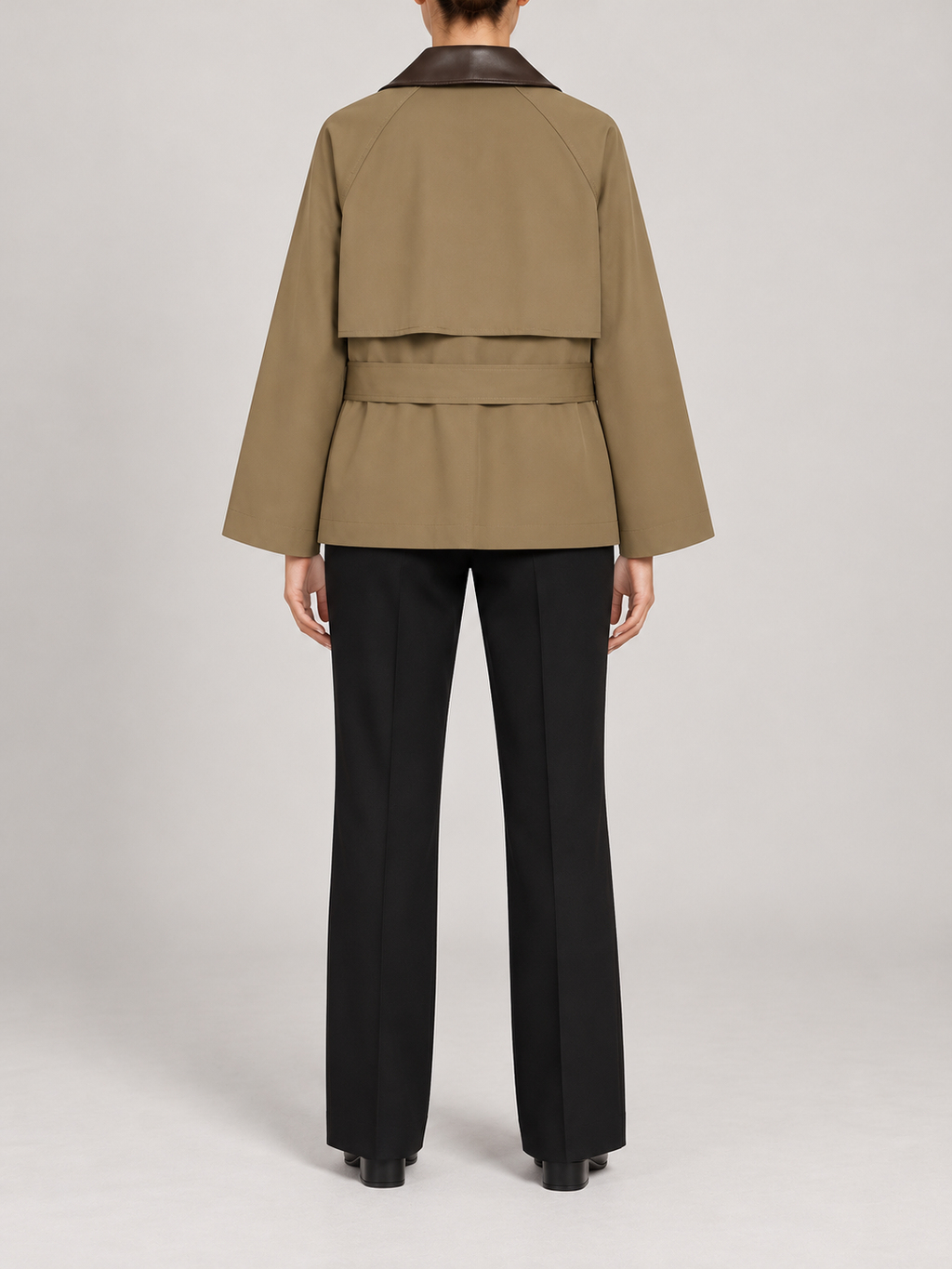 olive-khaki short belted trench with dark brown leather-look contrasting collar, broad lapels, buttoned flap pockets, back view on a model