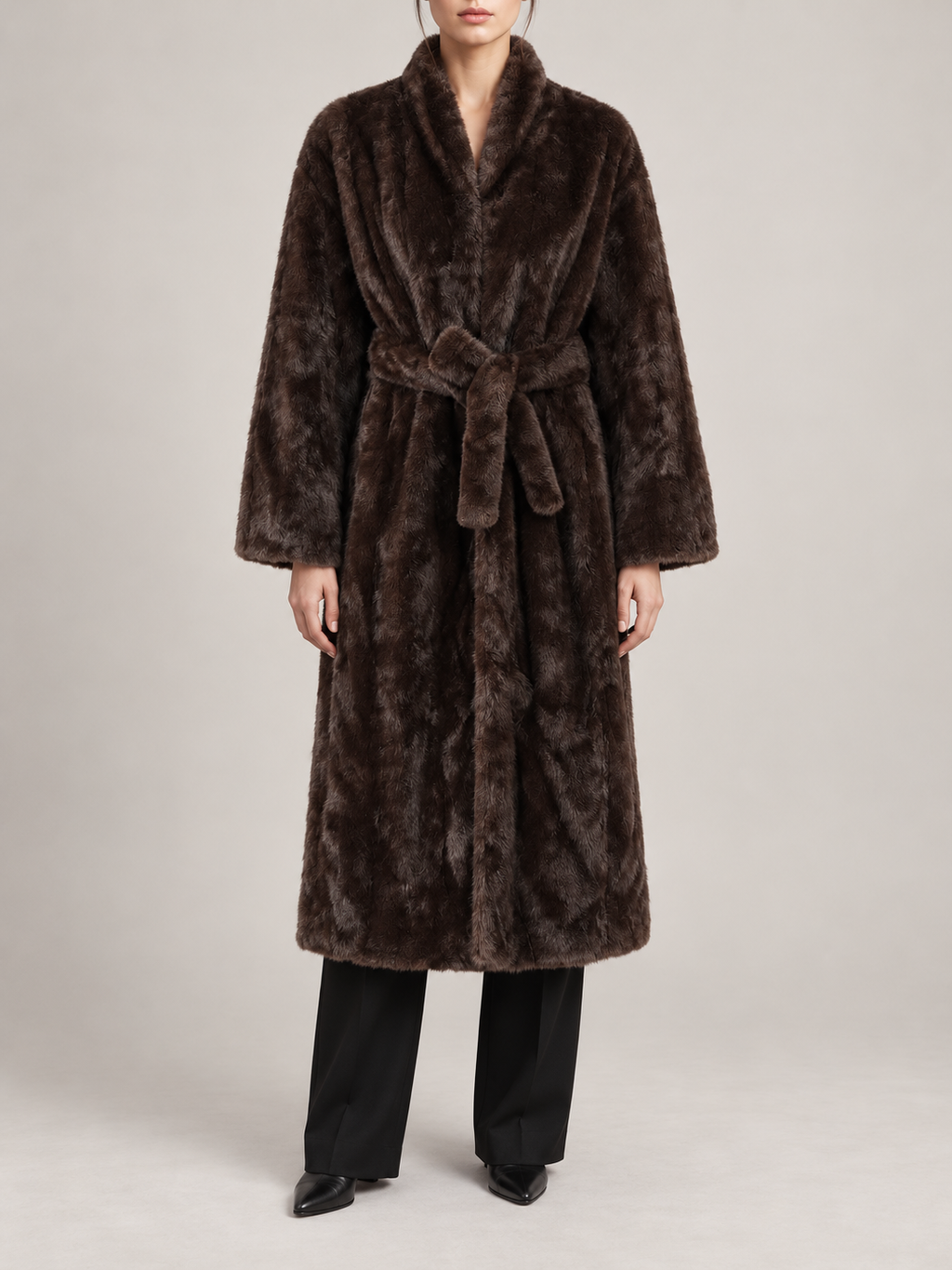 dark brown long faux-fur wrap coat with matching waist tie, slim rounded shawl collar, broad straight sleeves, front view on a model