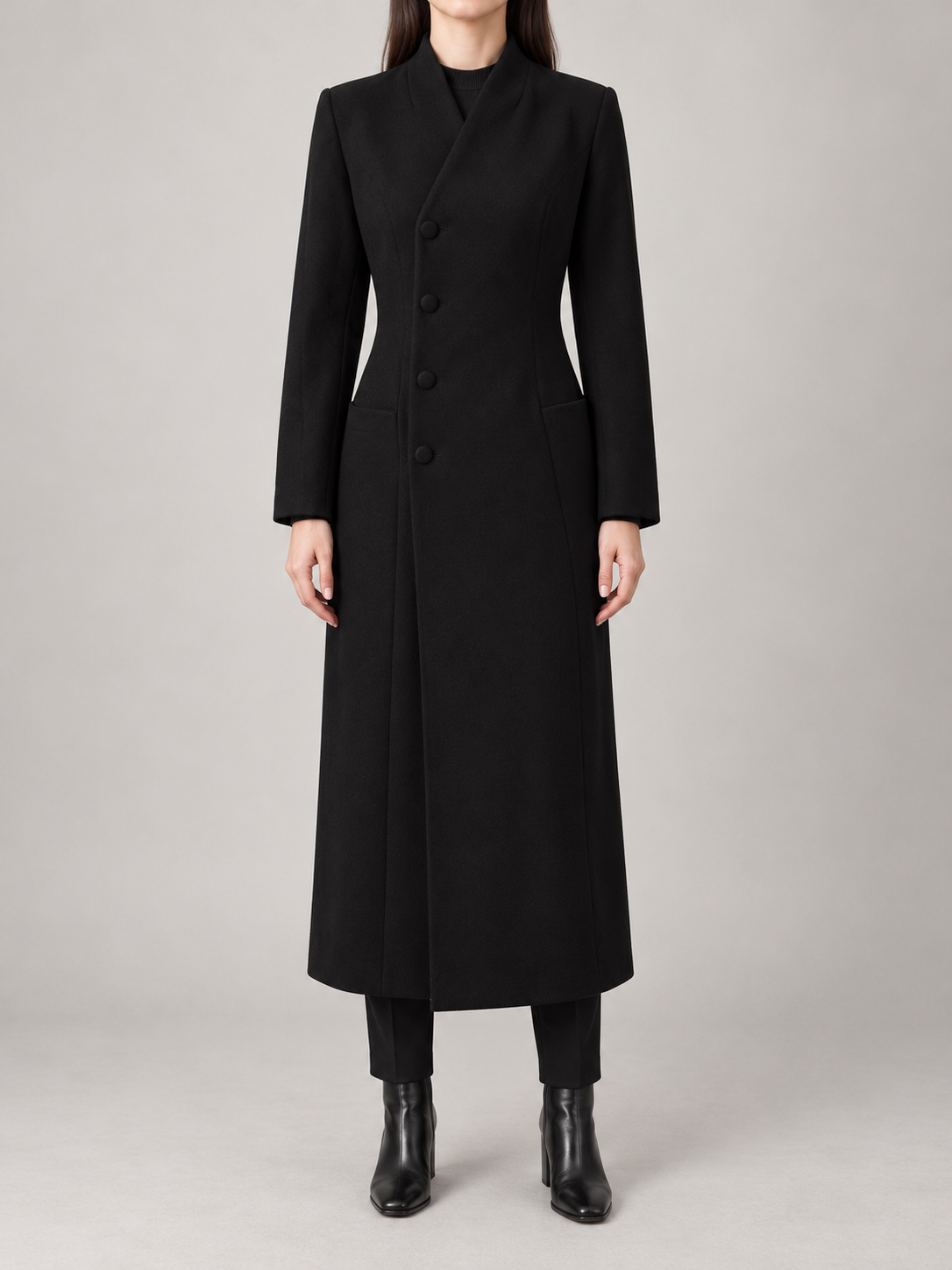 Black long tailored coat on a model, front view