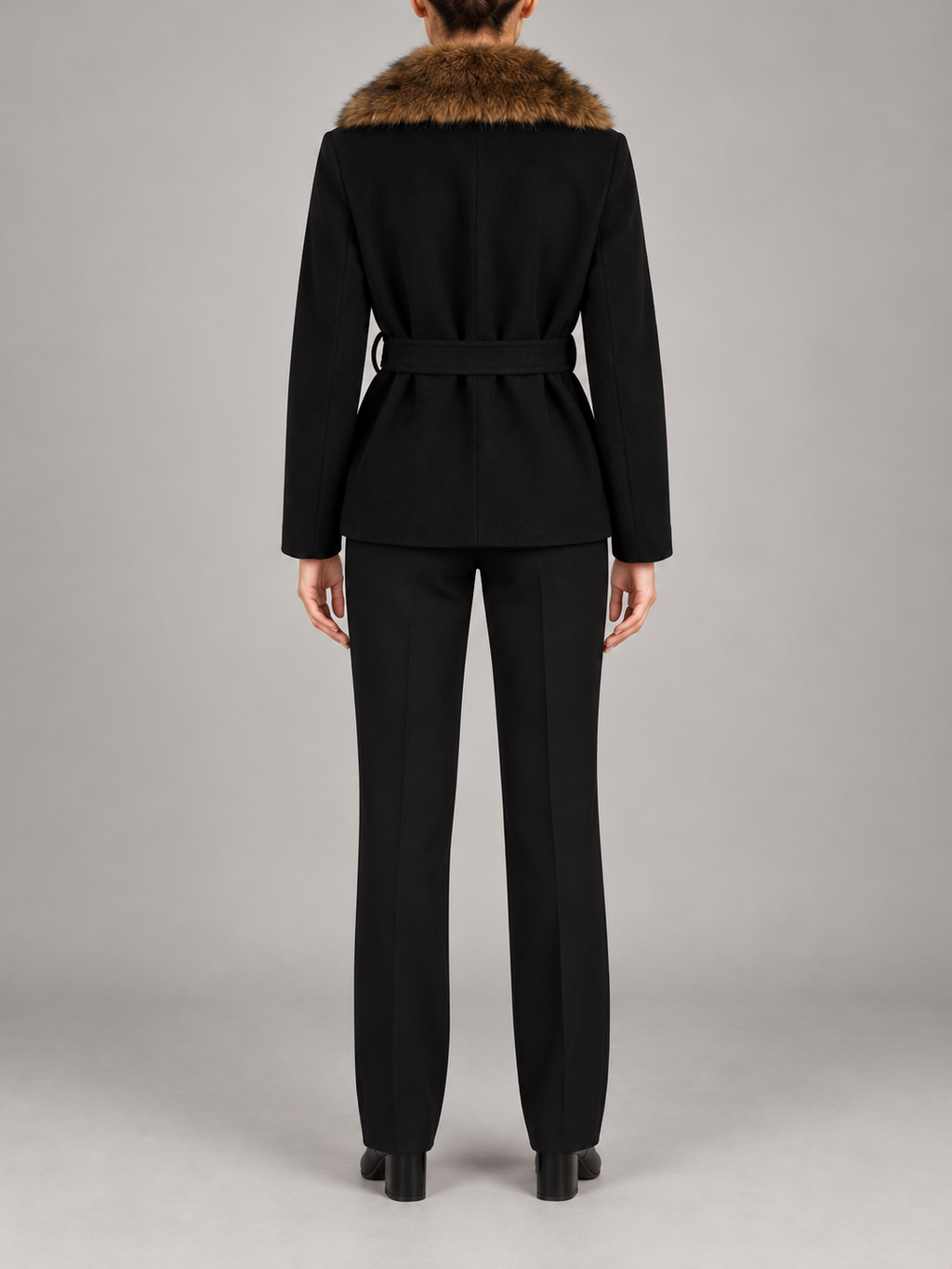 black hip-length wrap coat with brown faux-fur shawl collar and fabric waist tie, back view on a model