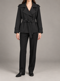 black double-breasted short trench with wide V-neck lapels, waist tie and buttoned cuff tabs, front view on a model